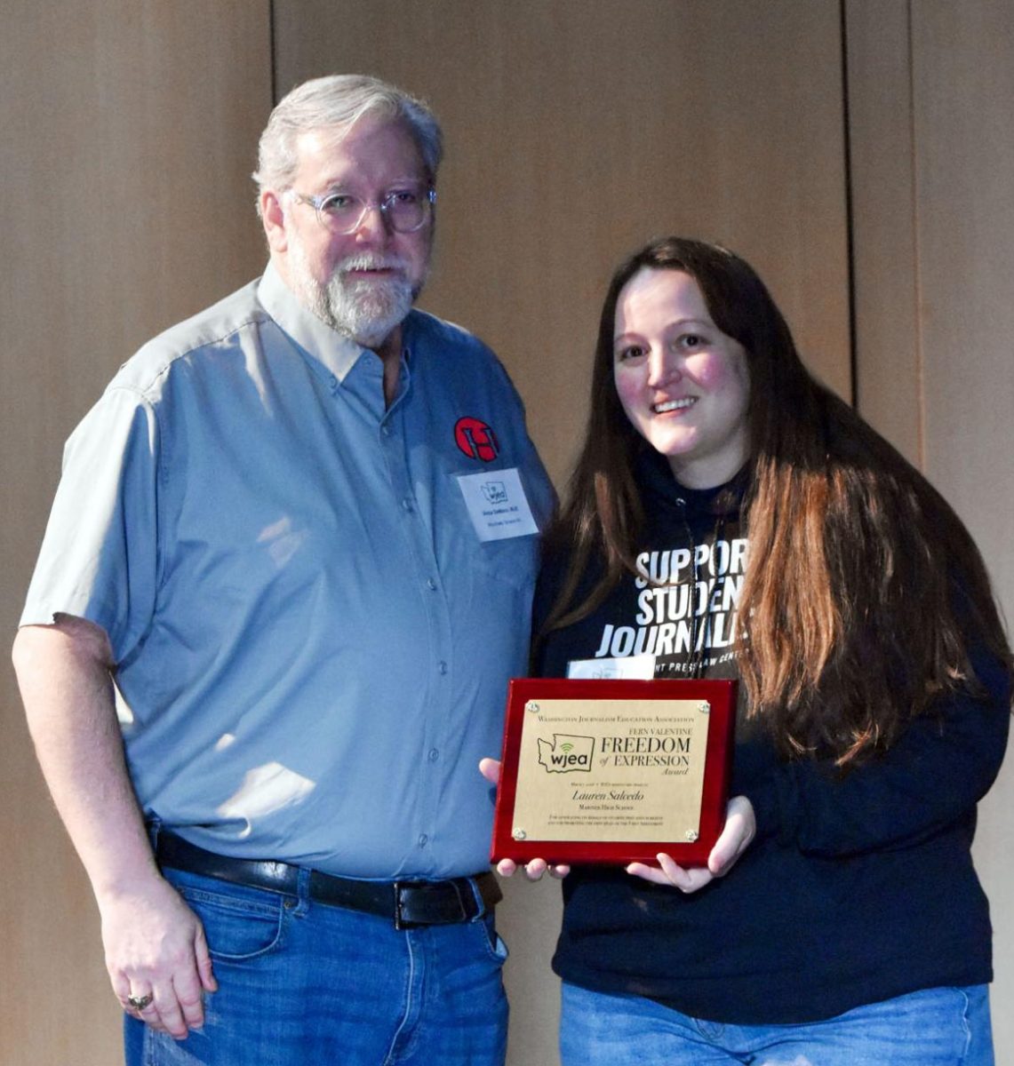 Vince DeMiero, Mountlake Terrace HS, presents the 2026 WJEA Fern Valentine Freedom of Expression Award to Lauren Salcedo, Mariner High School student media adviser for making sure her students know their First Amendment rights and responsibilities.